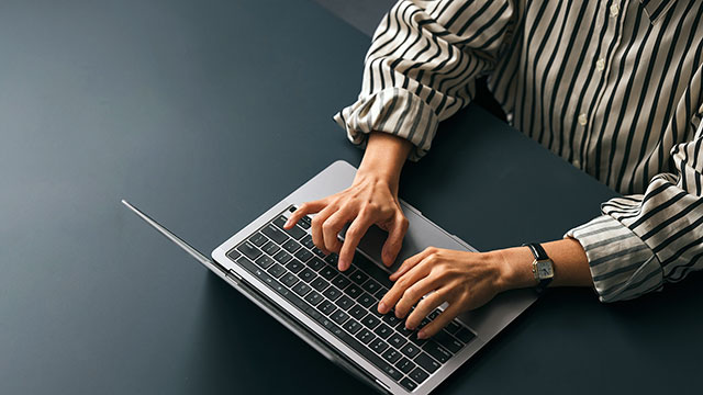 Person typing on the keyboard of a laptop